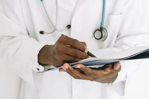 A clinician writing notes on a clipboard