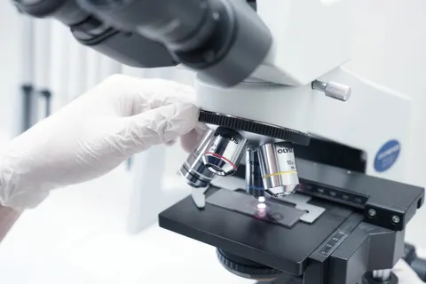 A microscope and gloved hands in a laboratory